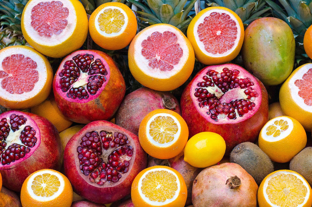 Colorful display of pomegranates, grapefruits, and oranges, showcasing vibrant fruits for puzzle enthusiasts.
