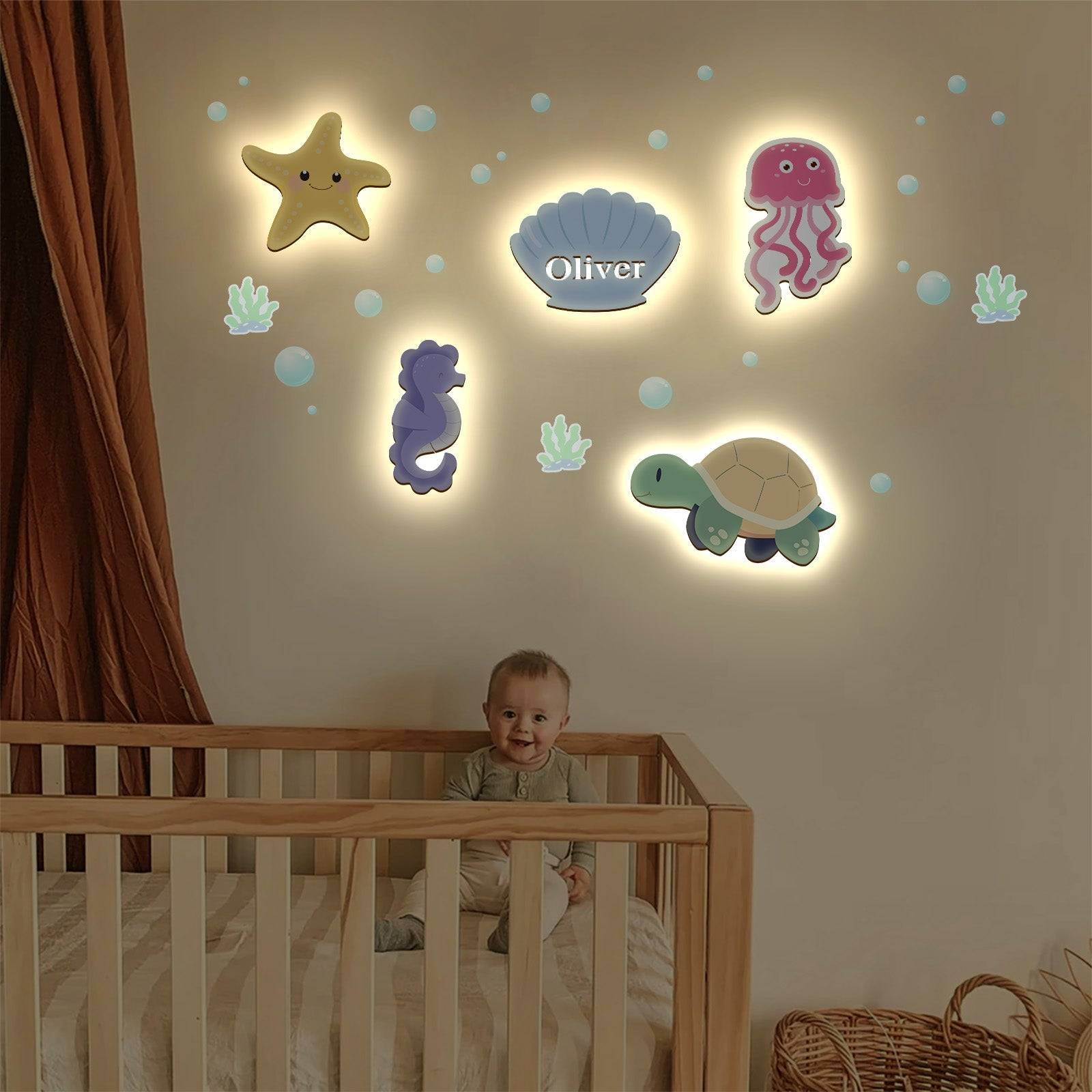 Personalized marine-themed wall lights featuring a starfish, jellyfish, seahorse, turtle, and a seashell with the name Oliver.