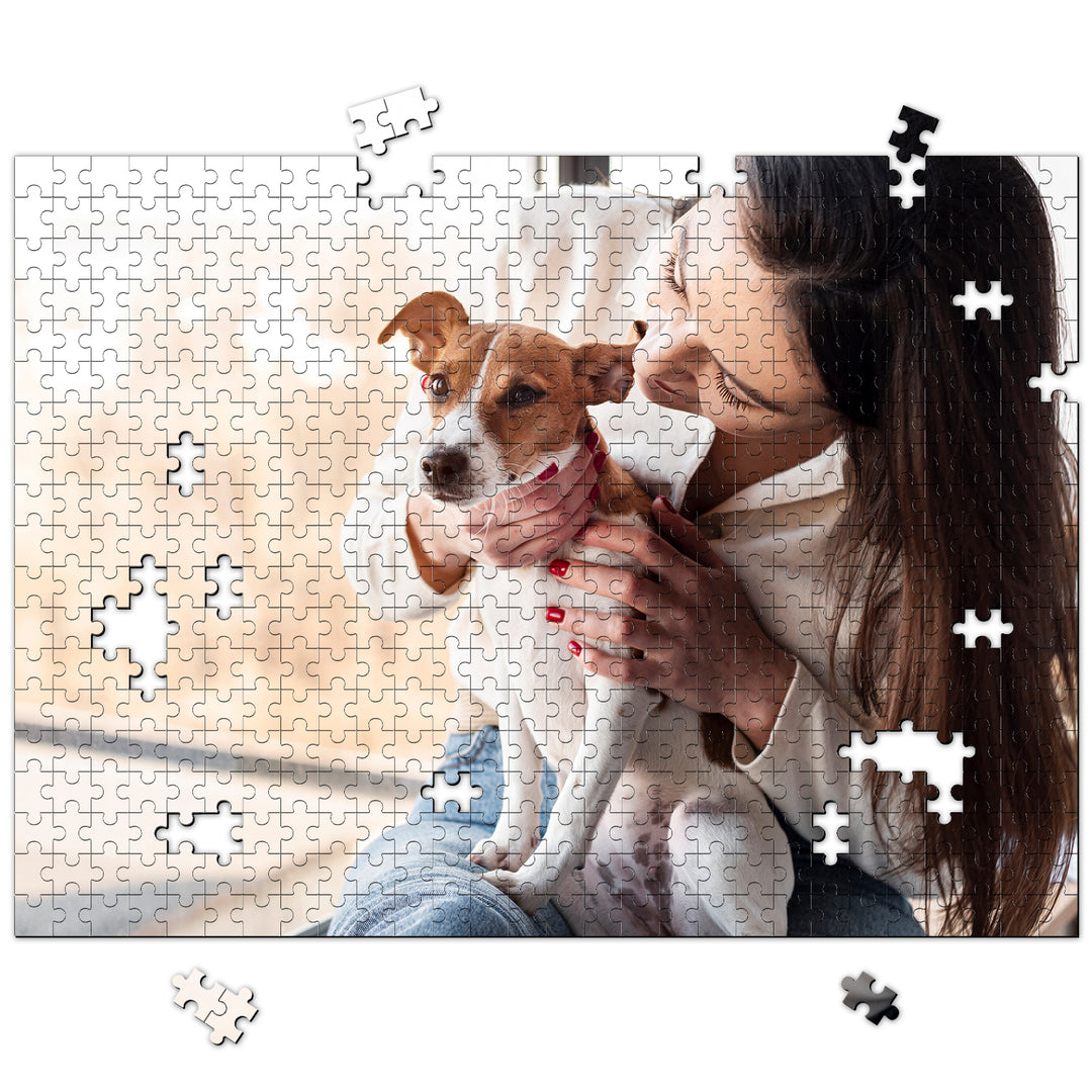 Woman holding her pet dog while putting together a custom jigsaw puzzle featuring their cherished photo.