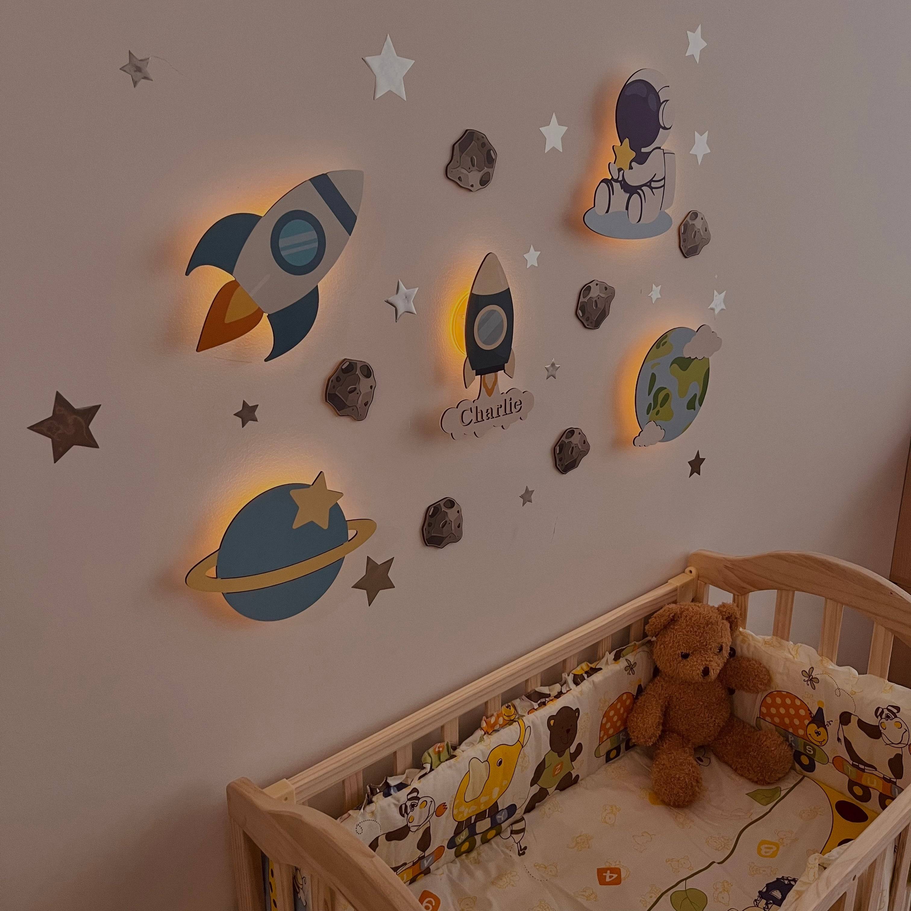 Personalized wooden baby room wall light set in space model with rocket, planet, and star designs, illuminating a cozy nursery.