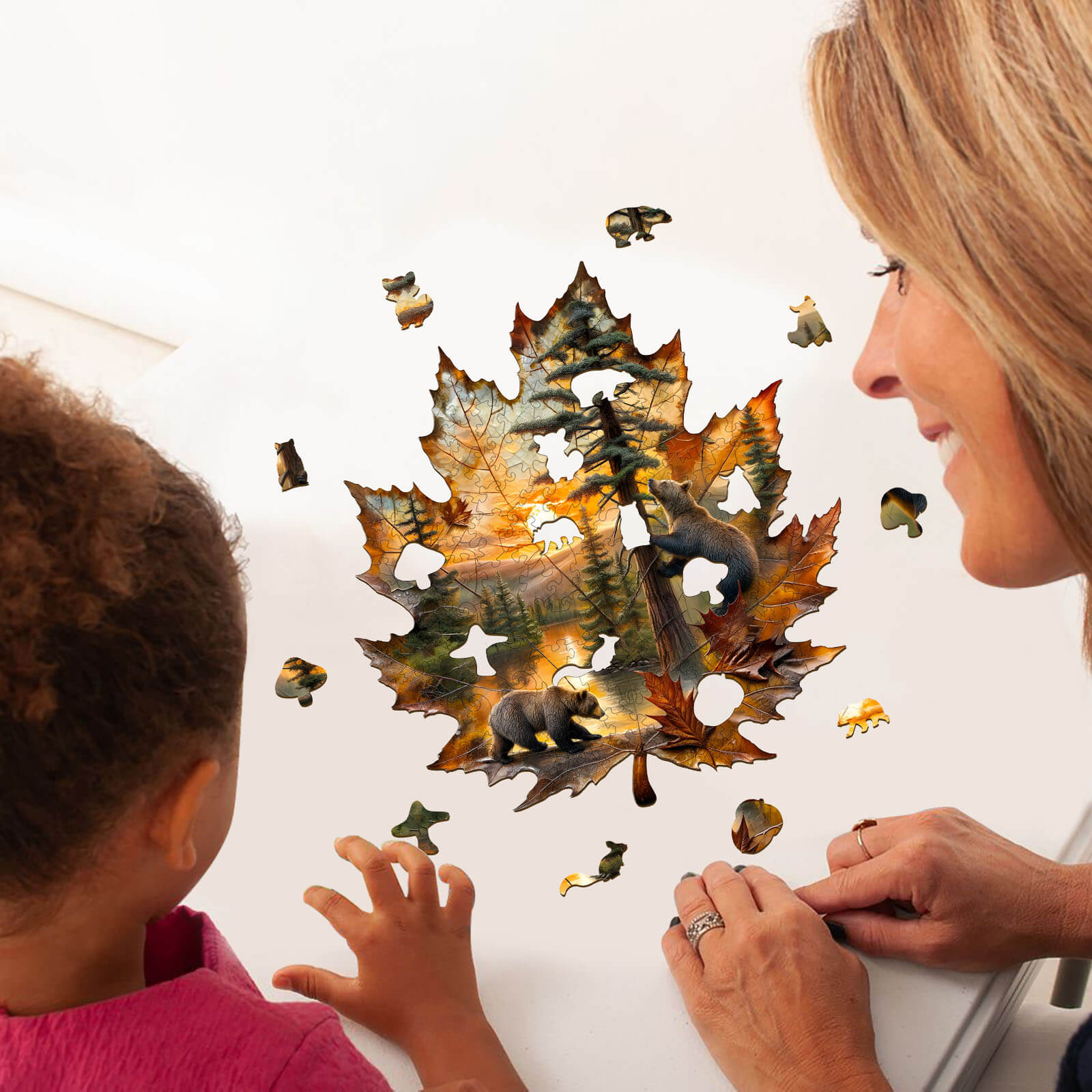 A child and an adult assembling a Brown Bear autumn wooden jigsaw puzzle shaped like a maple leaf.