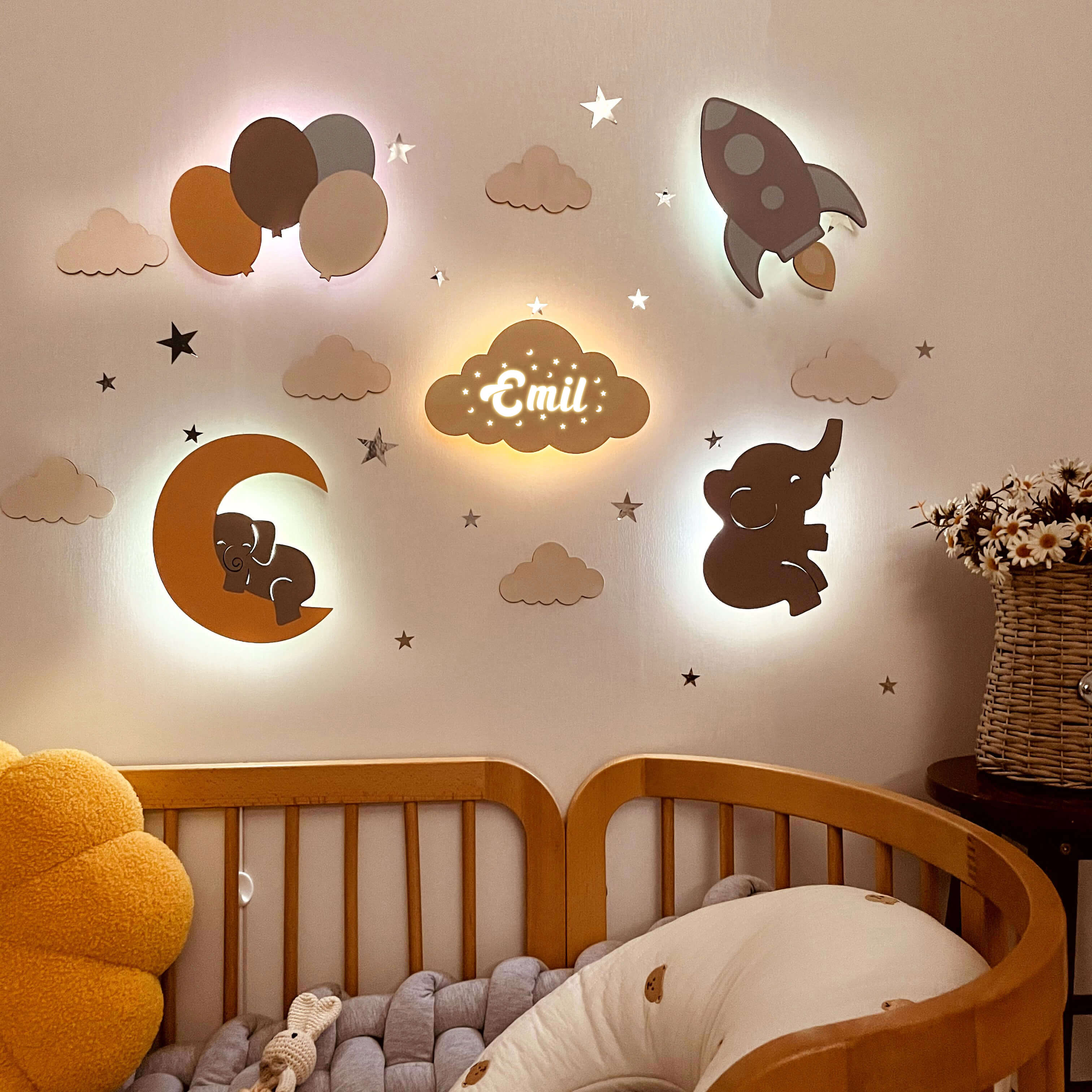 Personalized wooden baby room wall lights with balloons, moon, rocket, elephant, and stars, providing a comforting glow.