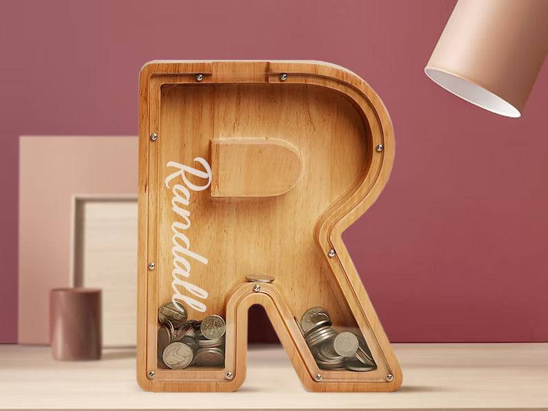 Personalised wooden letter piggy bank shaped like the letter R, ideal for teaching kids about saving money.
