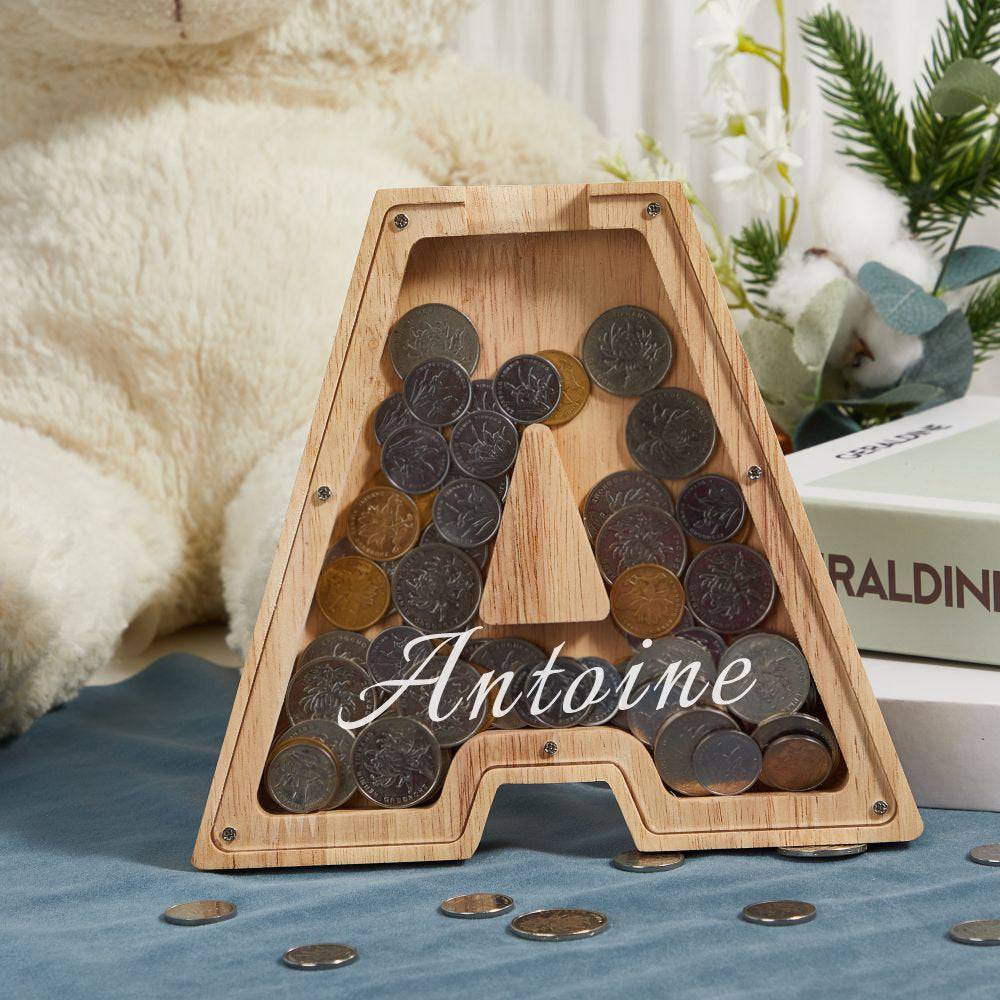 Personalized wooden letter piggy bank 'A' filled with coins, teaching kids the value of savings.