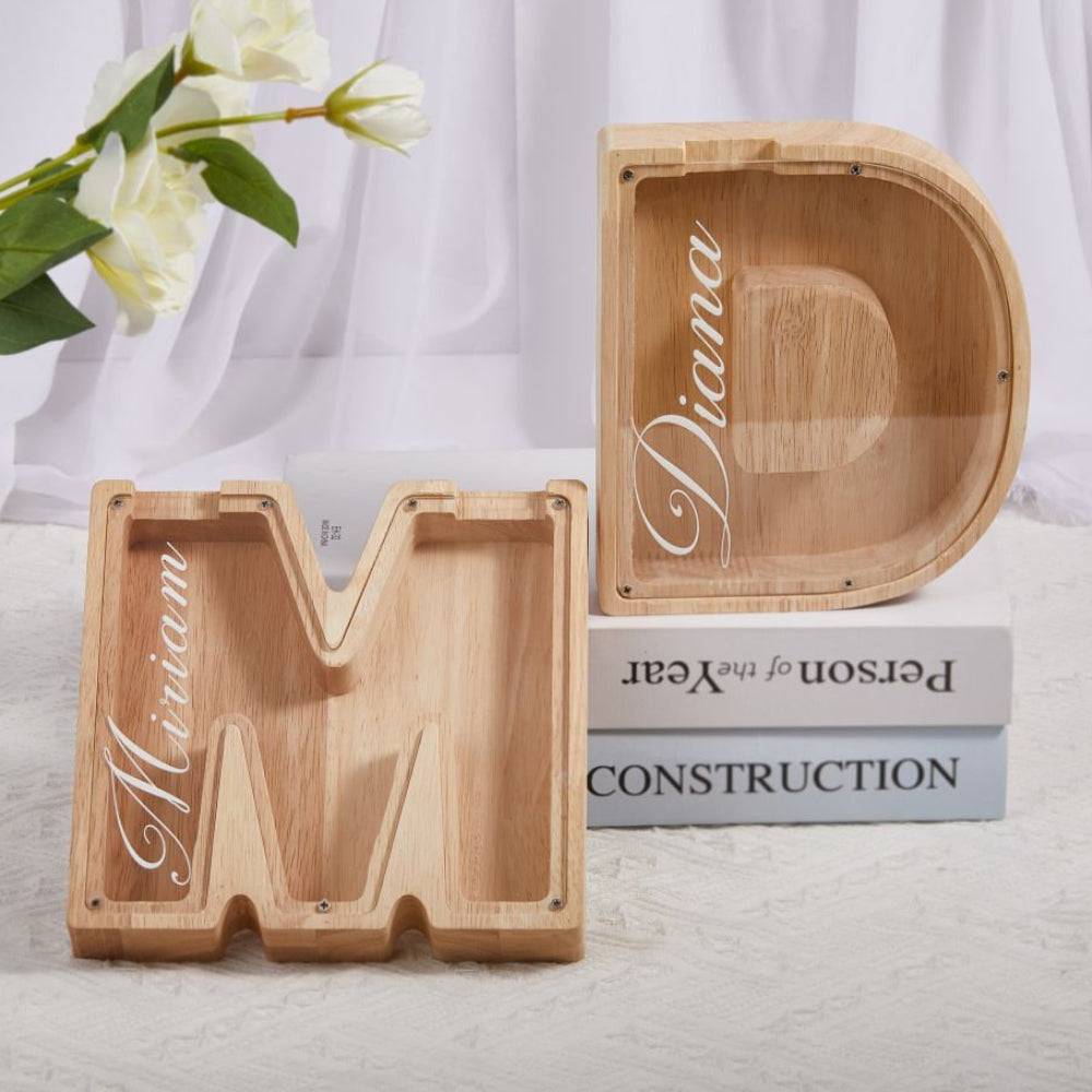 Custom wooden letter piggy banks 'M' and 'D' for kids to promote savings and financial awareness.