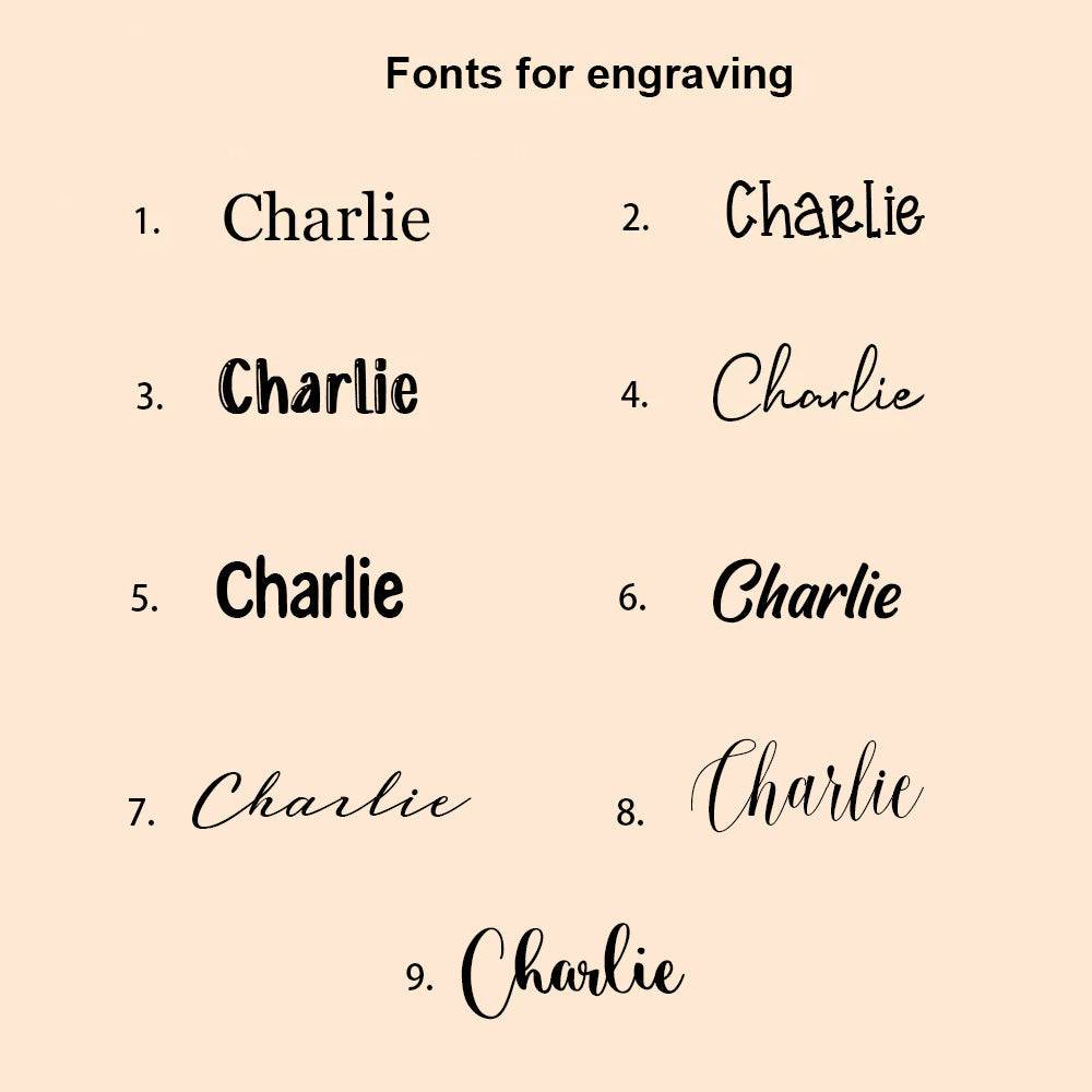 Various font options for engraving the name 'Charlie' on a custom wooden piggy bank.